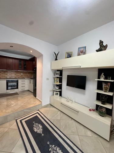un soggiorno con TV a schermo piatto e una cucina di Ina's apartment a Sarandë