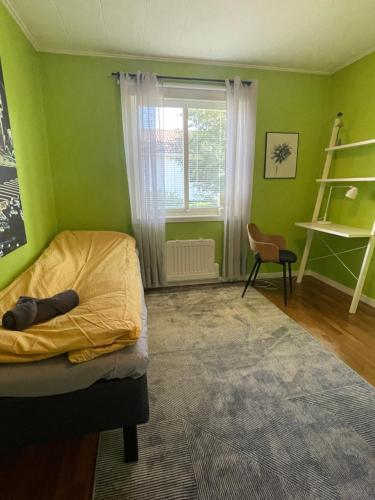 a green bedroom with a bed and a window at Centralt belägen villa i Öjebyn, Piteå in Piteå