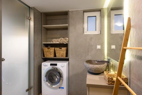 a laundry room with a washing machine and a sink at Cestrum Suites in Agios Nikolaos
