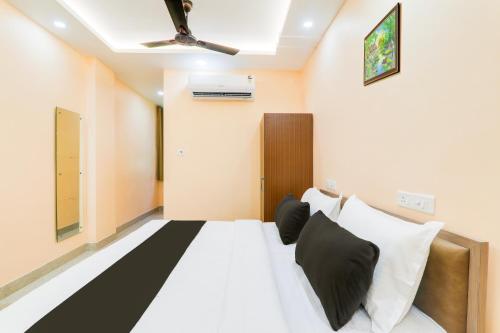 a room with a bed with black and white pillows at Hotel O Happy Times Vishveshwar Park in Gomti Nagar