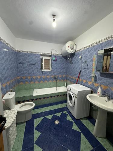 un bagno con due WC, un lavandino e una vasca di Ina's apartment a Sarandë