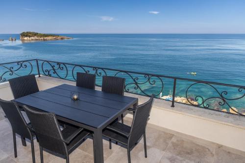 a table and chairs on a balcony with the ocean at Apartments Piano in Utjeha