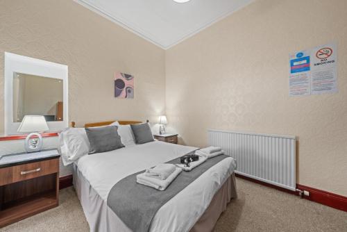 a bedroom with a bed with a cat laying on it at Struy Guest House - Inverness in Inverness