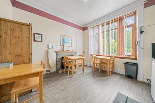 a living room with a table and chairs and a fireplace at Struy Guest House - Inverness in Inverness