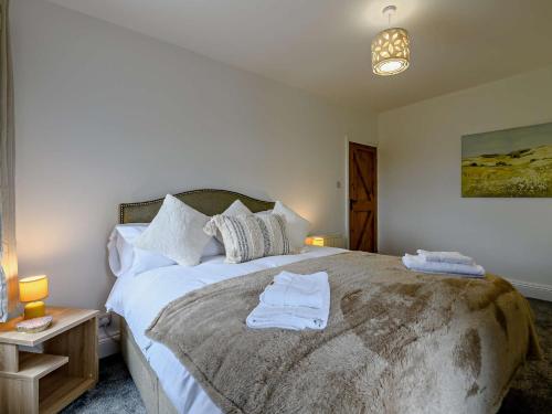 a bedroom with a large bed with towels on it at 5 Bed in Bingley 91977 in Bingley