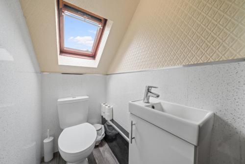 a bathroom with a toilet and a sink and a window at Struy Guest House - Inverness in Inverness