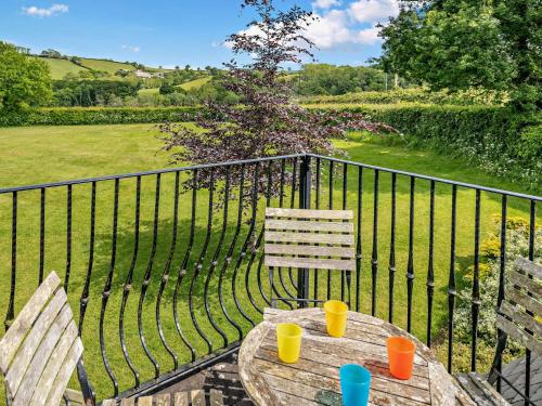 a wooden table with two cups on a balcony at 3 Bed in Crediton WAIE3 in Zeal Monachorum