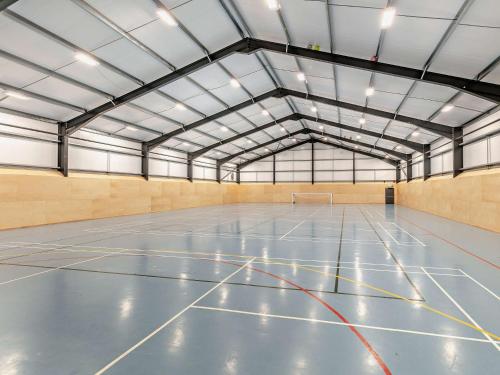 an empty gymnasium with a blue volleyball court at 3 Bed in Crediton WAIE3 in Zeal Monachorum