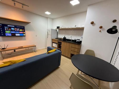 un salon avec un canapé bleu et une cuisine dans l'établissement Espaço Gentileza Moderno Studio na Lapa, à Rio de Janeiro