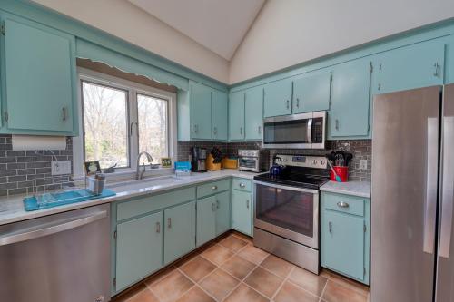 a kitchen with blue cabinets and stainless steel appliances at 4 Bedroom Home by Leavetown Vacations in Eastham