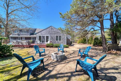 a group of blue chairs sitting in a yard at 4 Bedroom Home by Leavetown Vacations in Eastham
