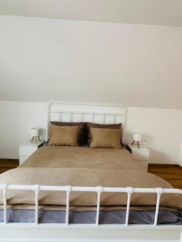 a white bed in a bedroom with two night stands at Apartma DUDI 