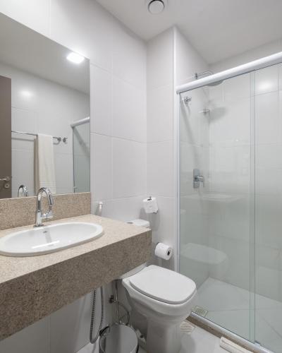 a bathroom with a toilet and a sink and a shower at Soft Inn Alagoinhas in Alagoinhas