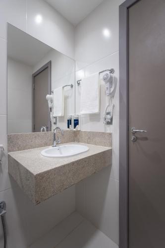 a bathroom with a sink and a mirror at Soft Inn Alagoinhas in Alagoinhas