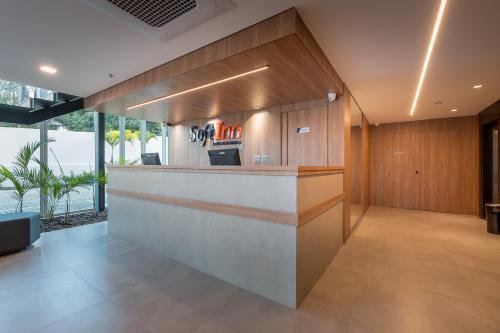 a lobby with a bar with wood paneling at Soft Inn Alagoinhas in Alagoinhas