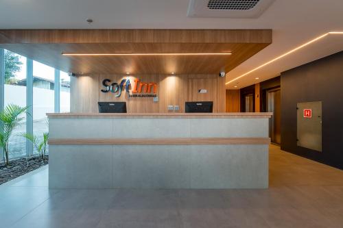 an office lobby with a reception counter with orange chairs at Soft Inn Alagoinhas in Alagoinhas
