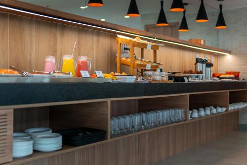 a kitchen with a counter with plates and drinks at Soft Inn Alagoinhas in Alagoinhas
