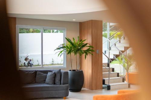 a living room with a couch and a staircase at Soft Inn Alagoinhas in Alagoinhas