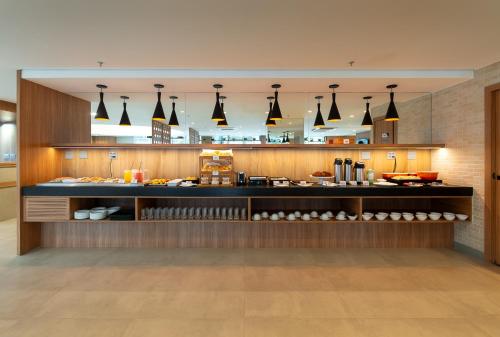 a restaurant kitchen with a counter with food at Soft Inn Alagoinhas in Alagoinhas