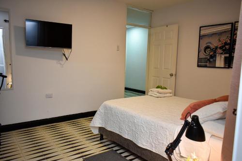 a bedroom with a bed and a flat screen tv on the wall at 10 Céntrico y Confortable apto Casa Doña Yola in Cartagena de Indias