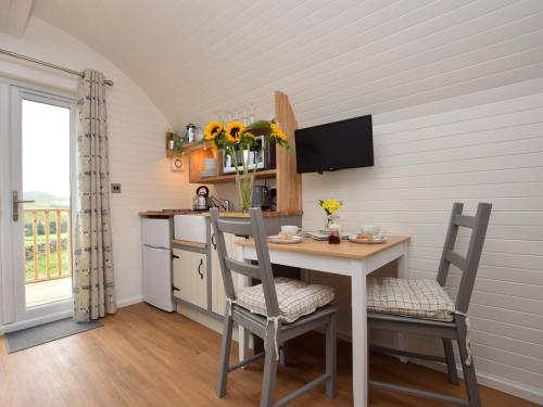 a kitchen with a table and chairs and a kitchen with a sink at 1 Bed in Teviothead 75347 in Hawick