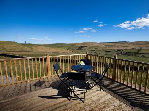 a table and chairs on a deck with a view at 1 Bed in Teviothead 75347 in Hawick