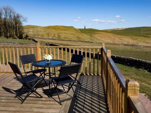 a table and chairs on a wooden deck at 1 Bed in Teviothead 75347 in Hawick