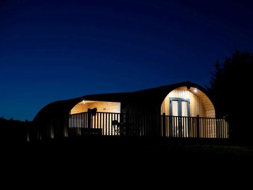 a round house with a black roof at night at 1 Bed in Teviothead 75347 in Hawick