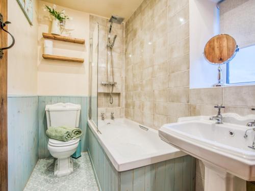 a bathroom with a tub and a toilet and a sink at 3 Bed in Hartington 77739 in Hartington