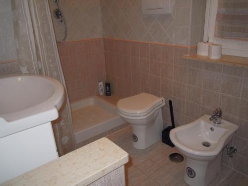 La salle de bains est pourvue de toilettes blanches et d'un lavabo. dans l'établissement La Loggetta, à Ischia di Castro