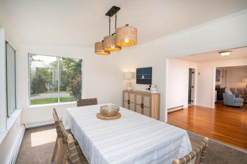 Un comedor con una mesa y sillas blancas. en Harwich Getaway by Leavetown Vacations, en Harwich