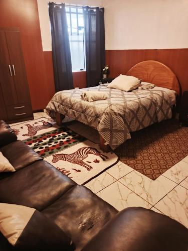 a bedroom with two beds and a couch at Casa Mirador guesthouse in Cusco