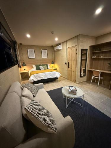 a living room with a couch and a bed at Manila Hotel Boutique in Medellín