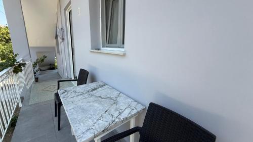 a table and chairs on the balcony of a house at Magdalini Garden House in Paralion astros