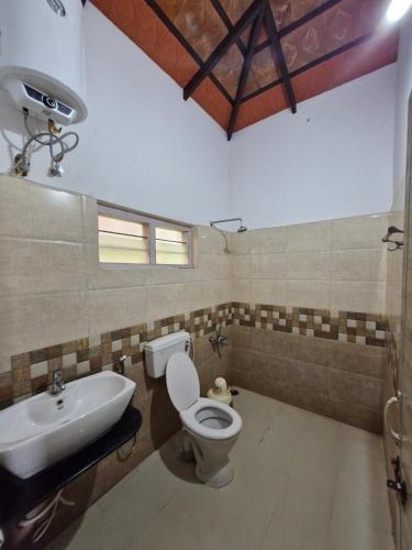 a bathroom with a toilet and a sink at MAYUR Home Stay in Suntikoppa