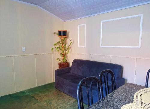 a living room with a blue couch and a table at Casa Aconchego in Presidente Epitácio