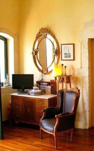a room with a desk with a chair and a mirror at Casa Leone Hotel in Chania Town
