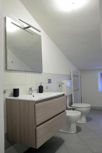 a bathroom with a sink and a toilet and a mirror at Locanda Il Gigante in Collagna