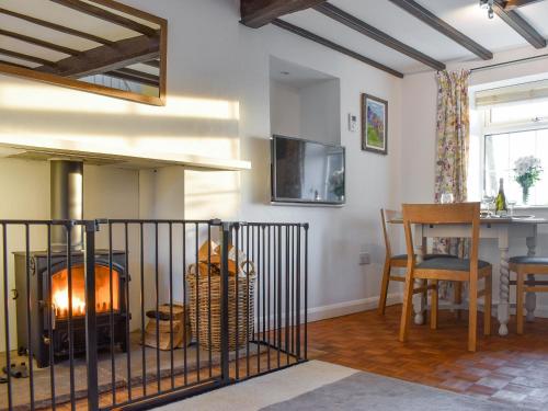 a living room with a fireplace and a table at New Cottage in Egton