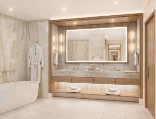 a bathroom with a tub and a large mirror at Green Valley Ranch Resort Spa Casino in Las Vegas