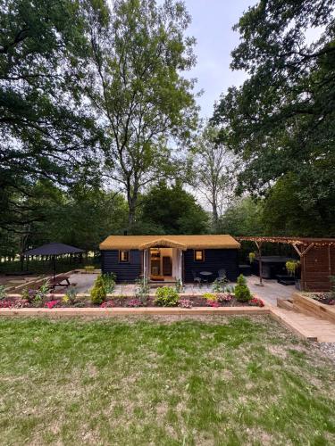 a tiny house in a yard with a garden at Charlton's Hollow in Bolney