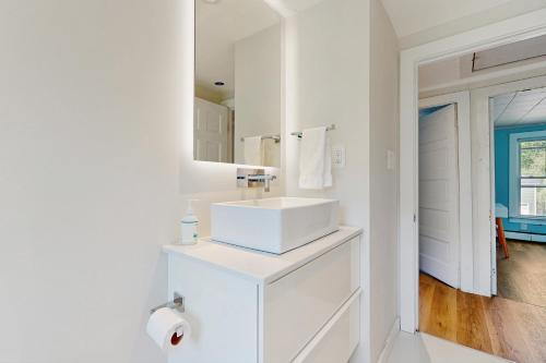 a white bathroom with a sink and a mirror at Salt Air Serenity in Old Orchard Beach