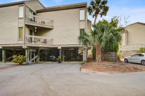 a house with a palm tree and a car parked in front at 1641 Courtside in Seabrook Island