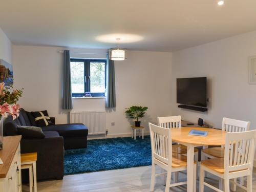 a living room with a table and a couch at St Andrews Place in Stratton