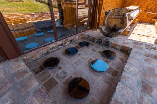 an outdoor kitchen with bowls on a stone floor at Hotel Qvevrebi in Tʼelavi