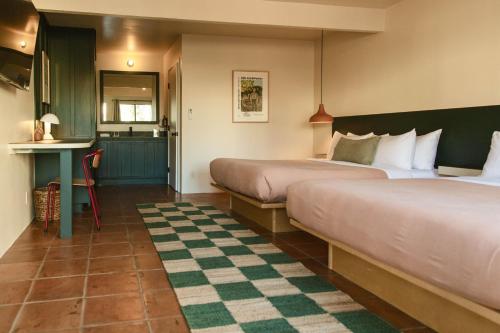 a hotel room with two beds and a checkered floor at Hummingbird Inn in Ojai