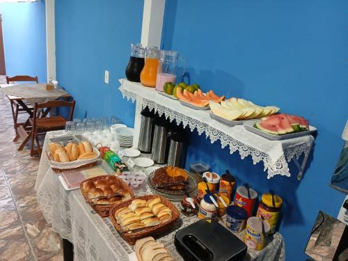 a table topped with lots of bread and other foods at Pousada Milagres de Maria in Aparecida