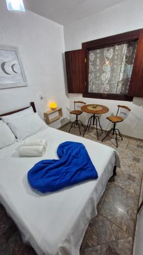 a bedroom with a bed with a blue blanket on it at Casa Miranda in Trindade