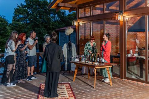 a group of people standing around a table with wine glasses at Hotel Qvevrebi in Tʼelavi