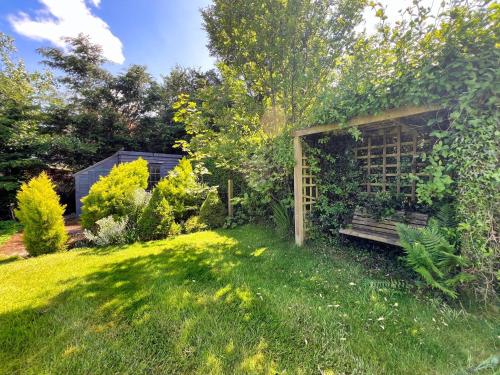 a garden with a wooden bench in the grass at 2 Bed in Wooler 92074 in Wooler